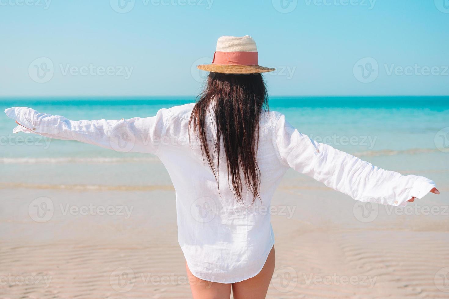 Woman laying on the beach enjoying summer holidays looking at the sea photo