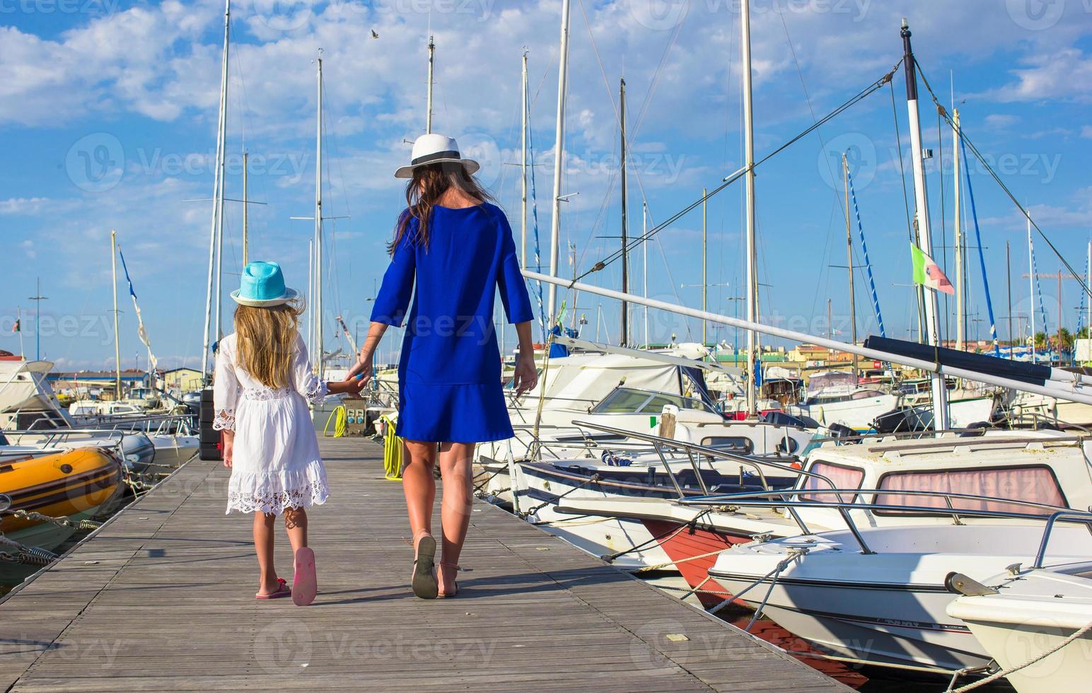 joven madre con una niña en el puerto disfrutando de un día soleado de verano foto