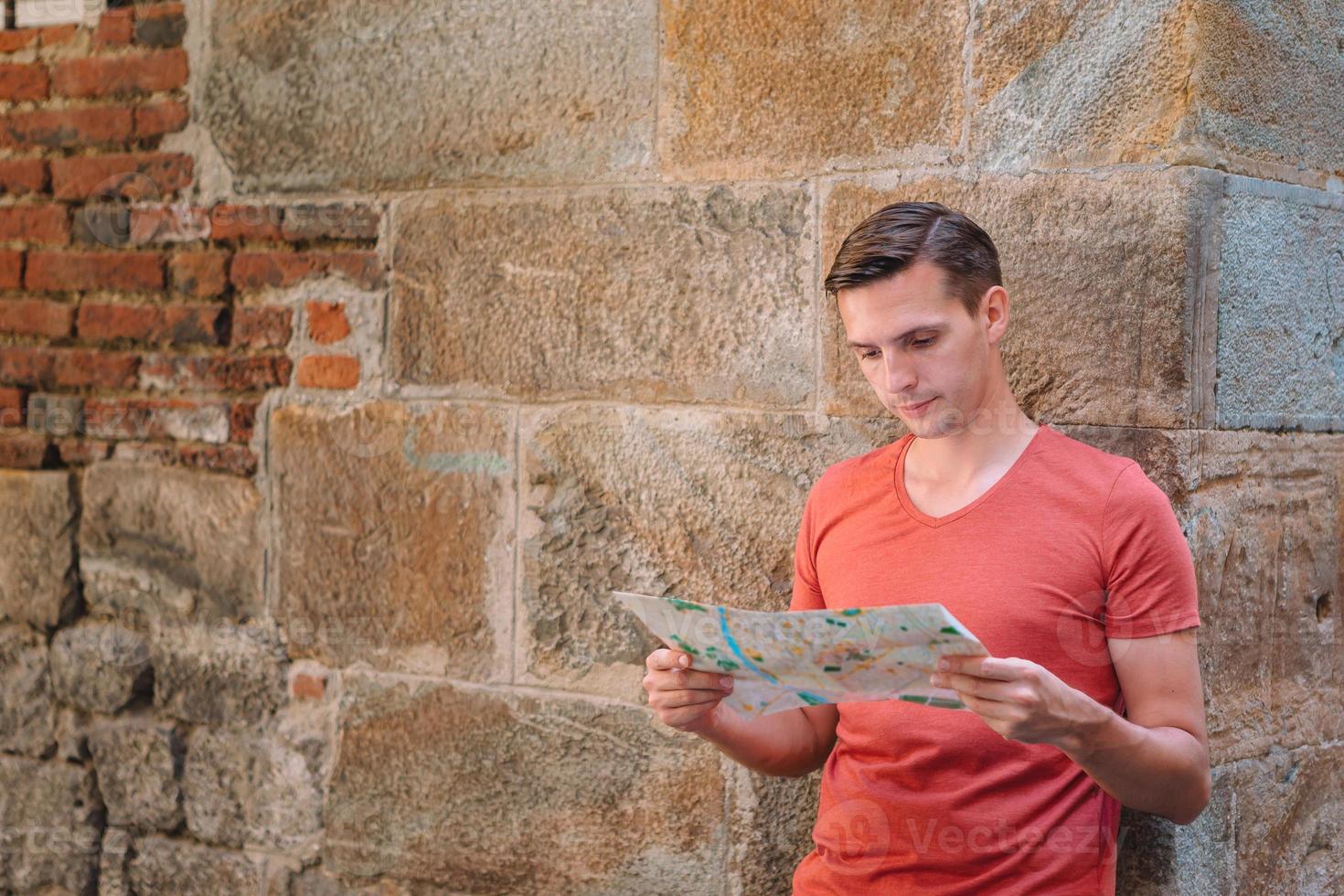 Young man with a city map in european city. photo