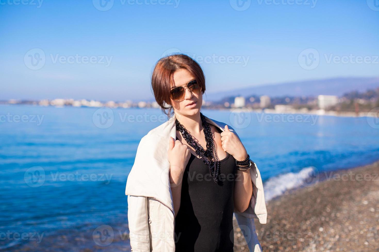 retrato de una hermosa joven caminando por la playa en un día soleado de invierno sola foto