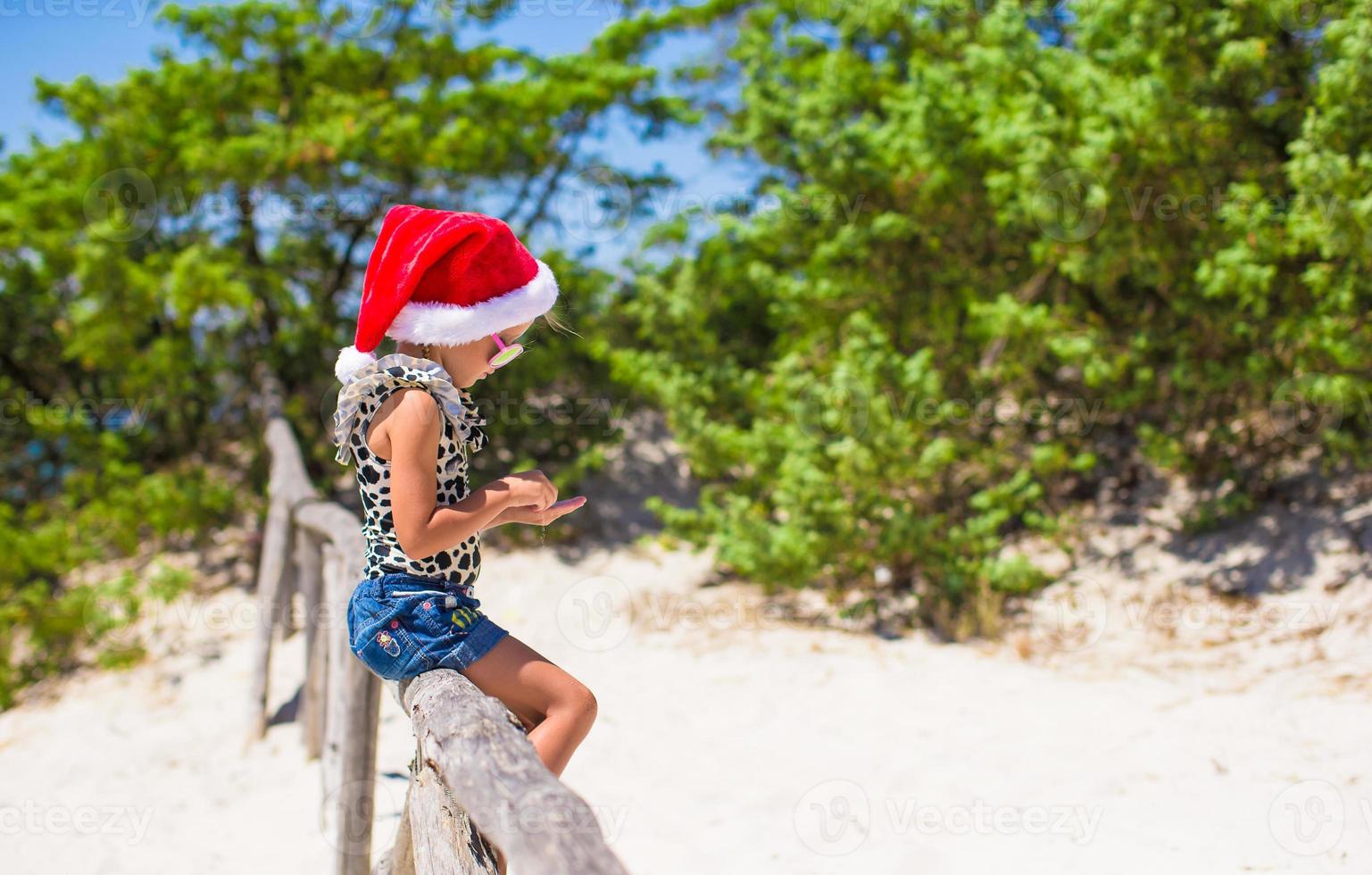 Cute beautiful little girl in Santa hat during vavation photo