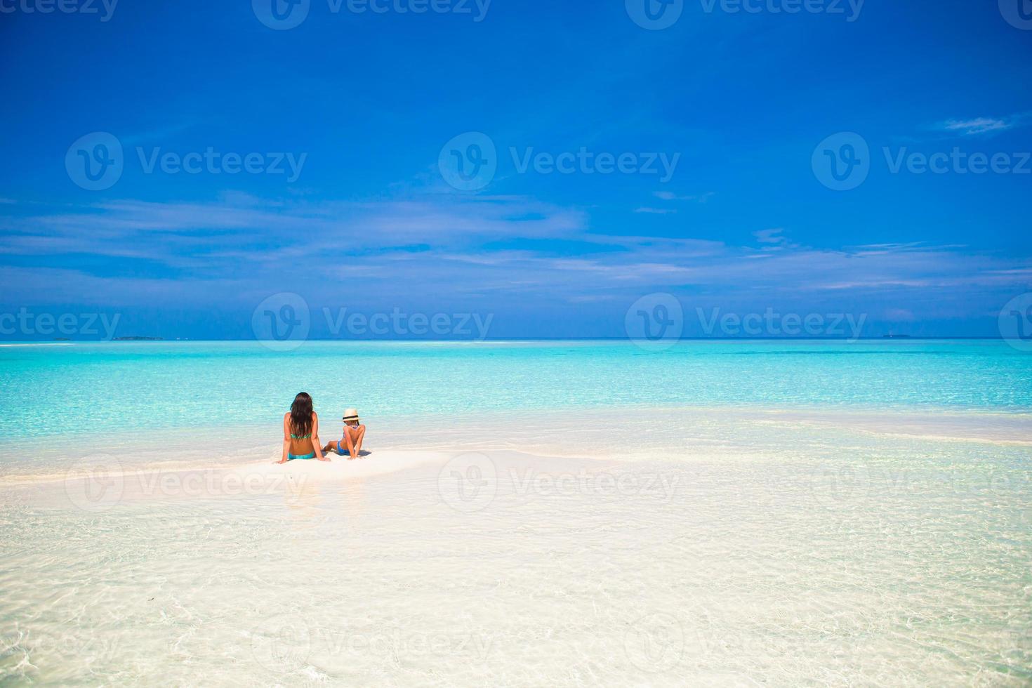 niña y madre joven durante las vacaciones en la playa foto