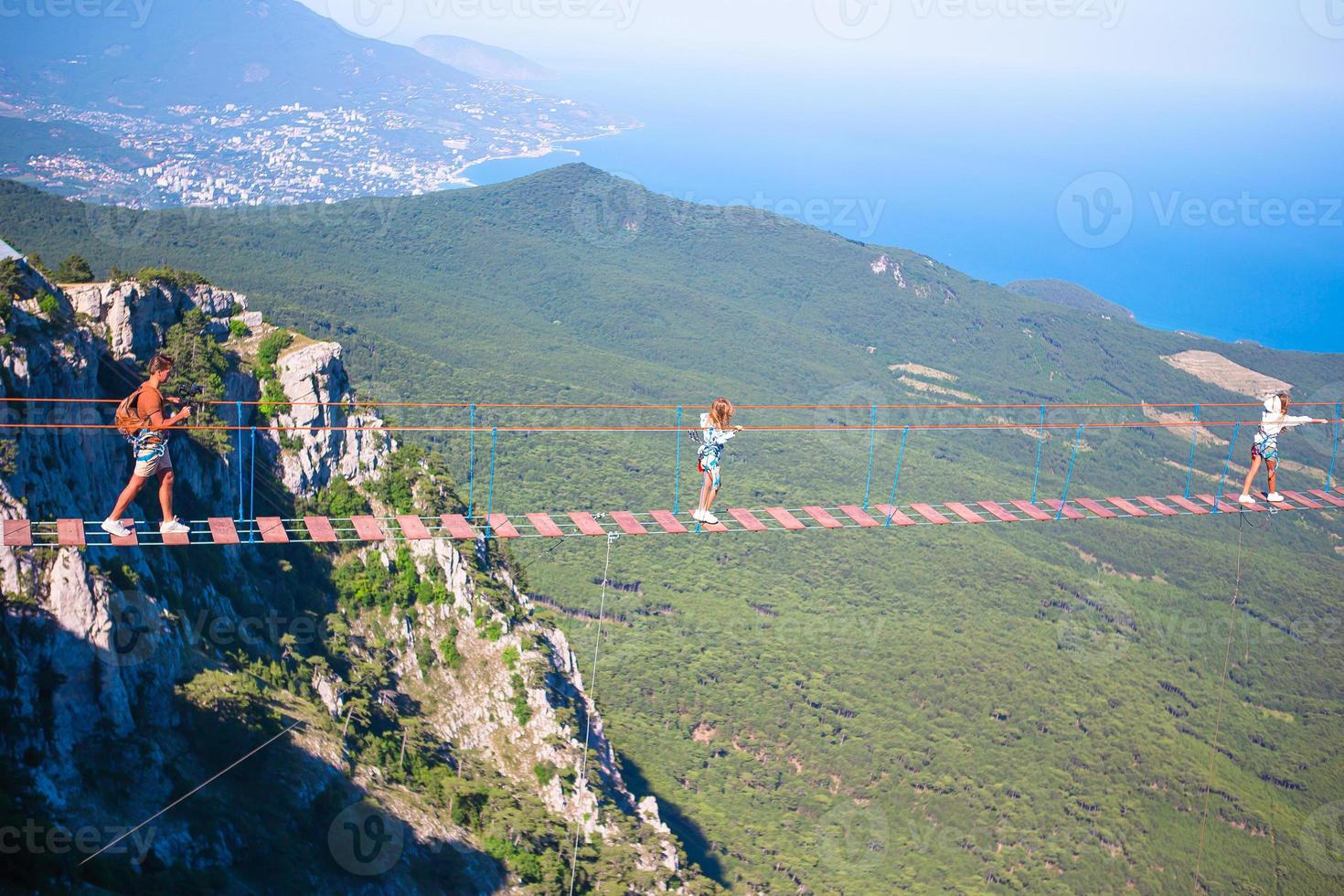 familia cruzando el abismo en el puente de cuerda. fondo del mar negro, crimea, rusia foto