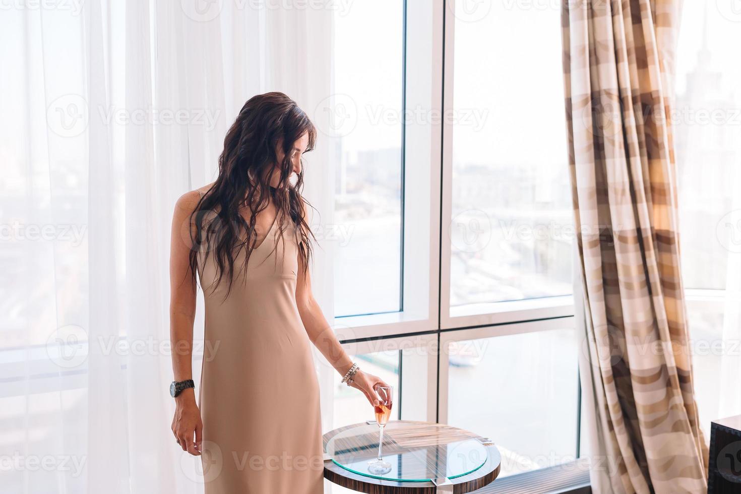 hermosa joven con un vestido largo en el hotel en la fiesta foto