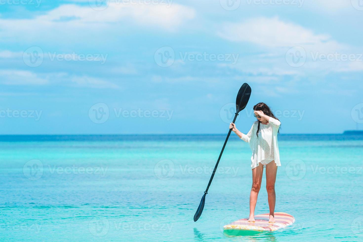 mujer joven activa en stand up paddle board foto