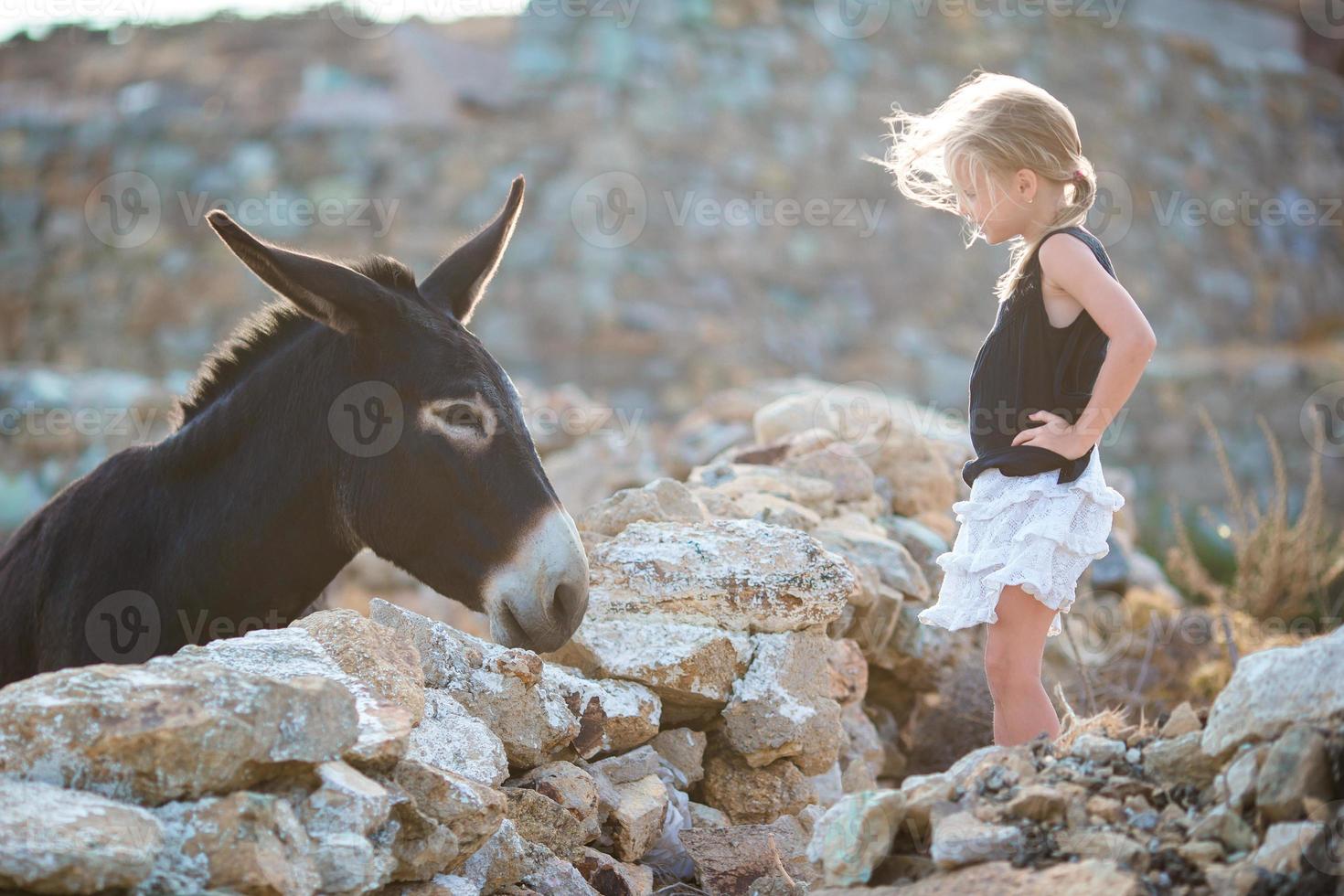 Little adorable girl with donkey on Mykonos photo