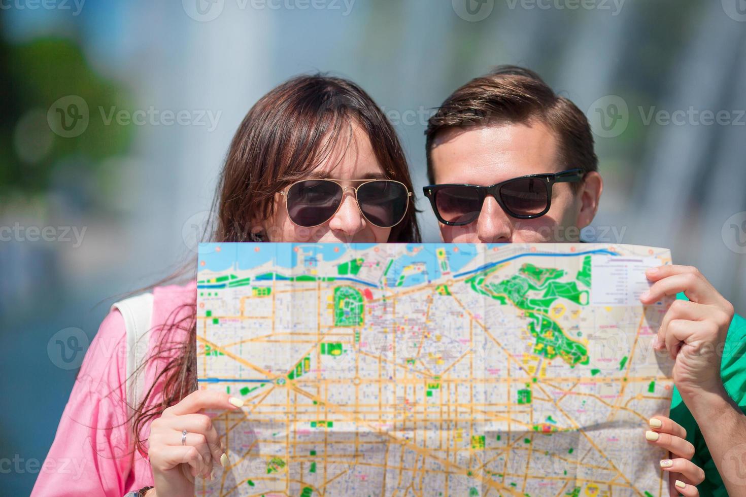 Young tourist friends traveling on holidays in Europe smiling happy. Closeup caucasian family with city map in search of attractions photo