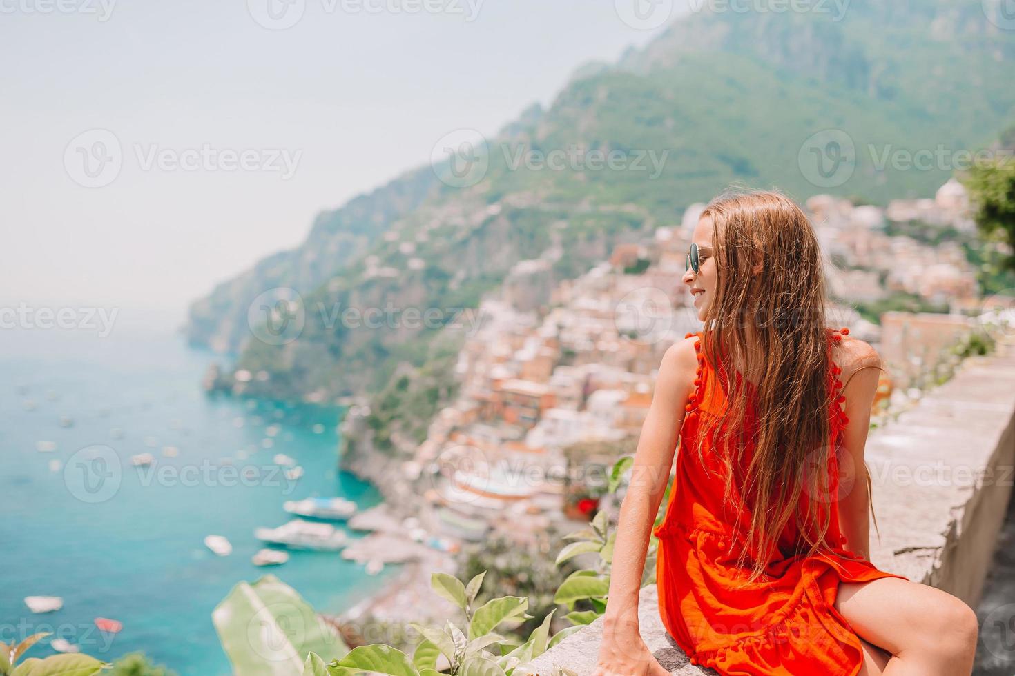 Adorable little girl on warm and sunny summer day in Positano town in Italy photo