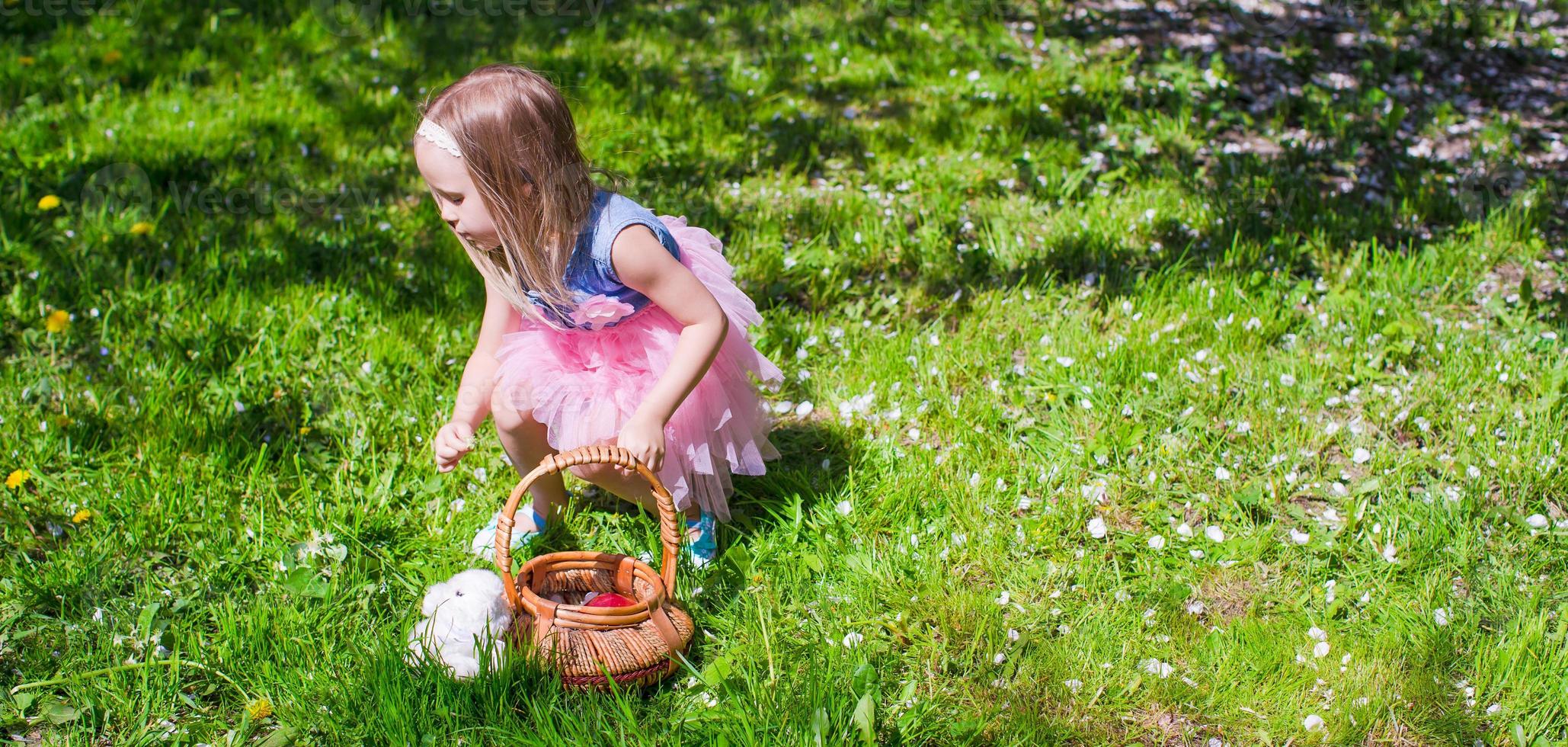 Happy little adorable girl in blossoming apple garden photo