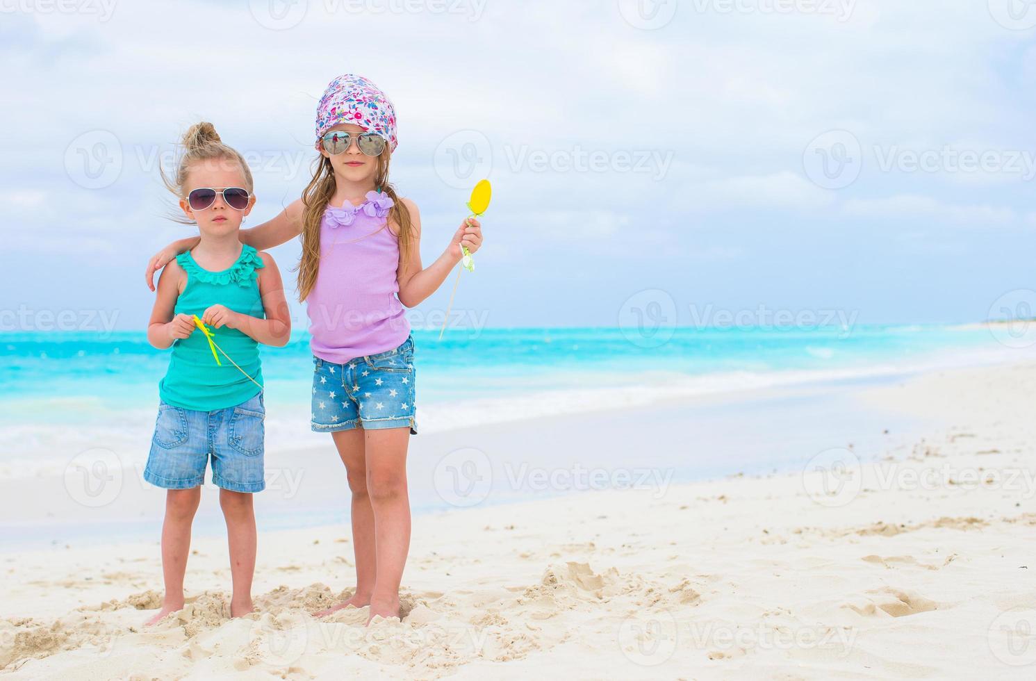 Little adorable girls during tropical beach vacation photo