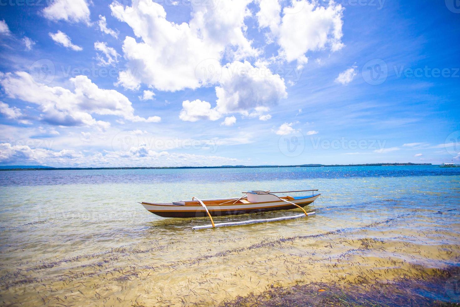 Small Fishing boat on white tropical beach photo