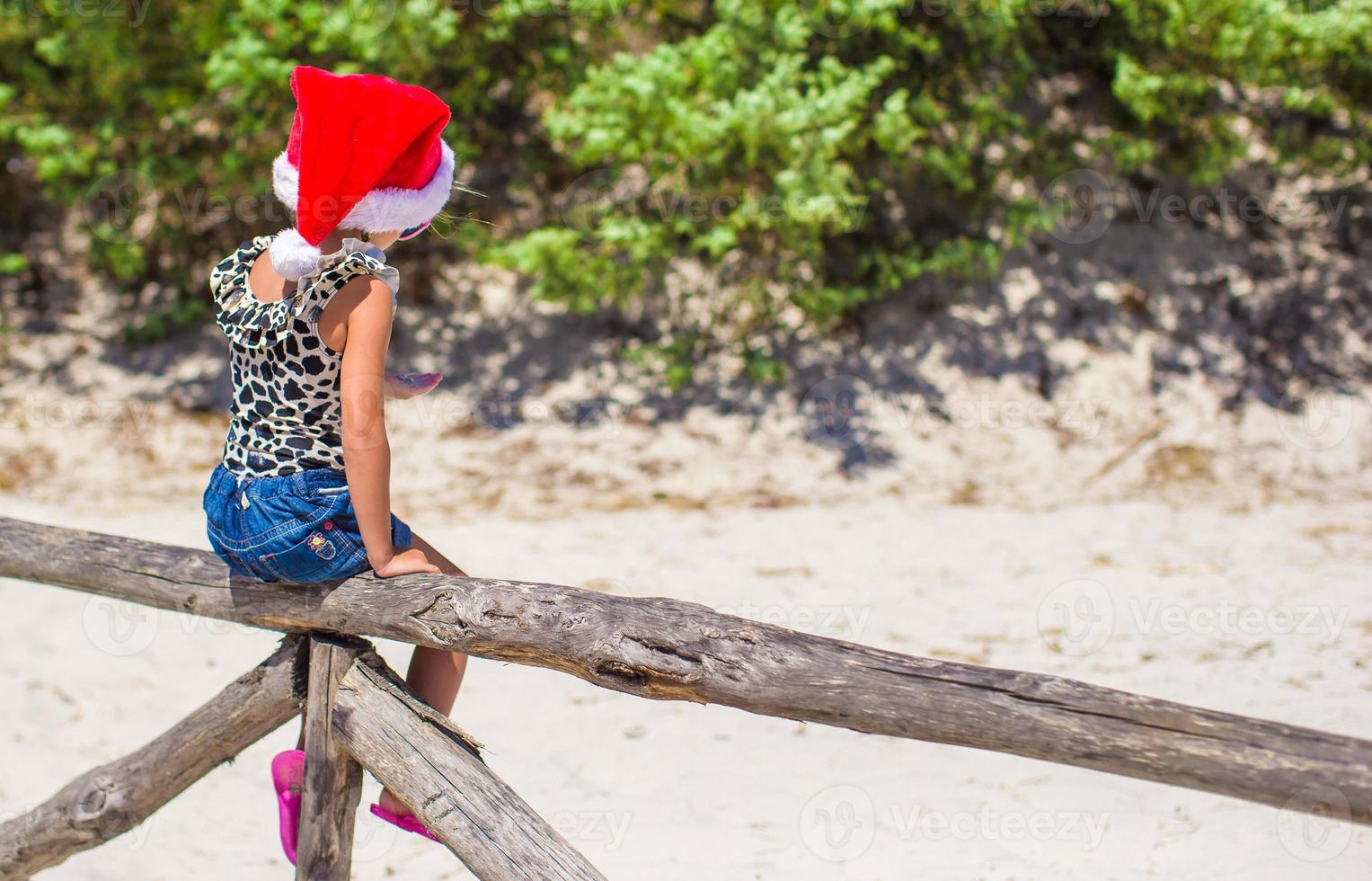 linda niña hermosa con sombrero de santa durante las vacaciones foto