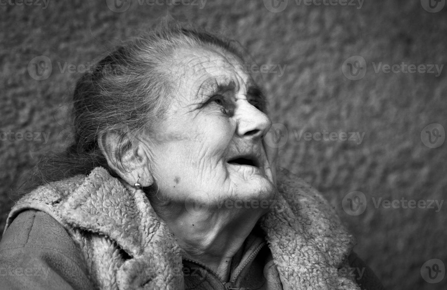 Very old and tired wrinkled woman outdoors photo