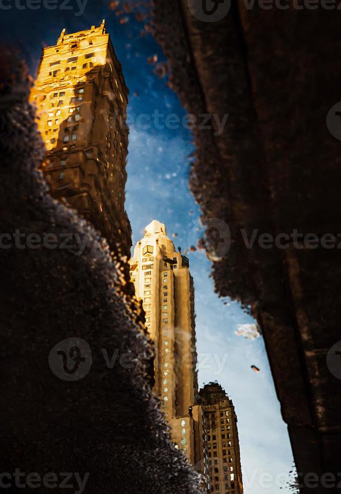 Streets of Manhattan. Skyscrapers reflection in puddles photo