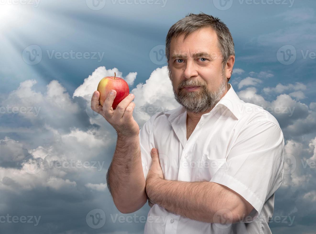 hombre de mediana edad sosteniendo una manzana roja foto