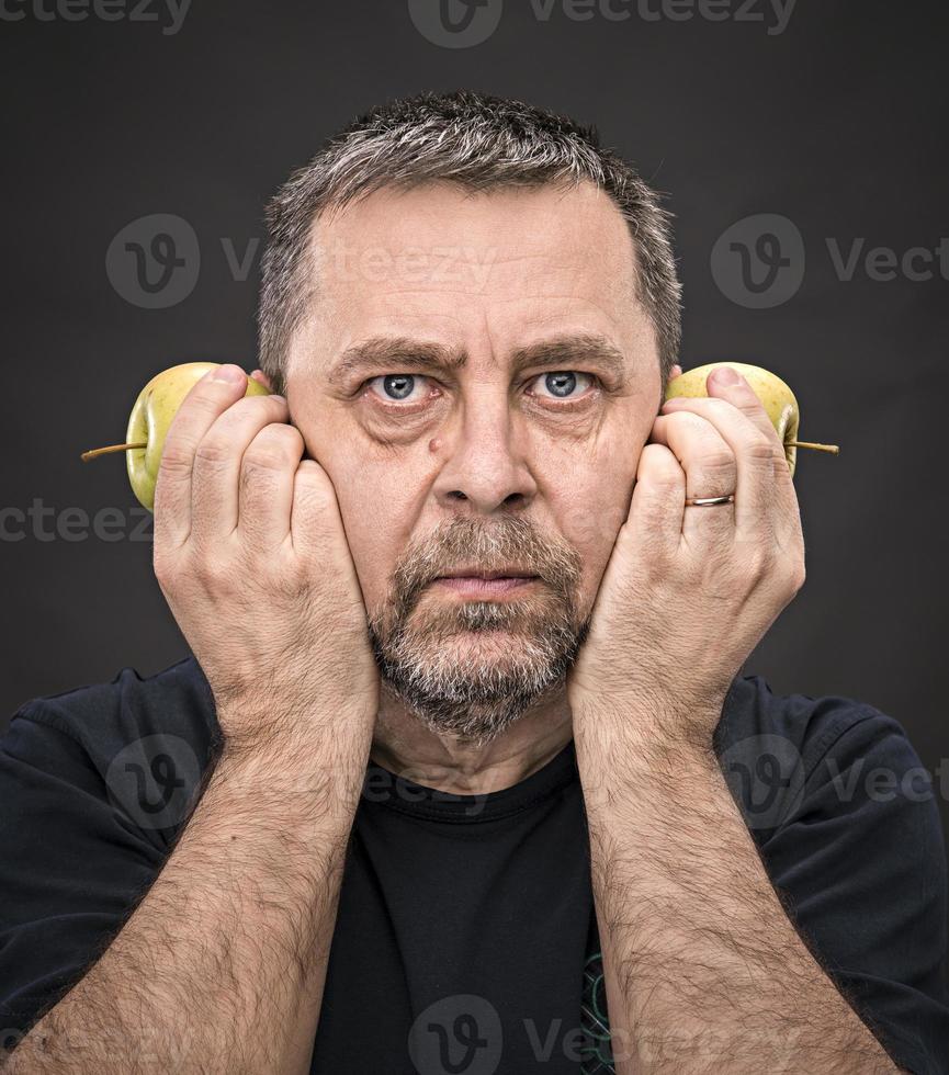 hombre de mediana edad con manzanas verdes foto