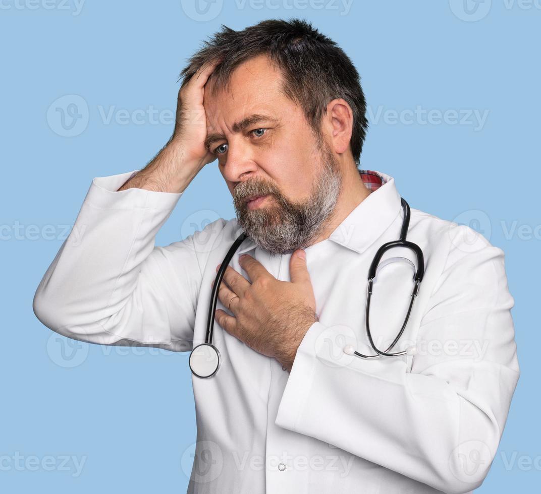 Thoughtful doctor isolated on blue photo