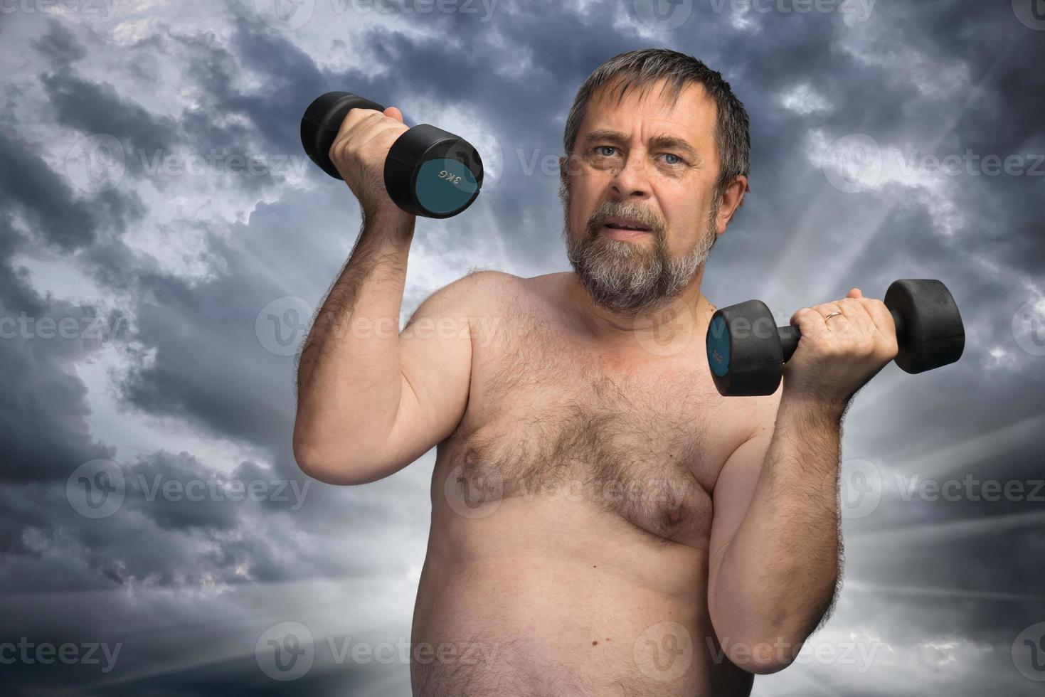 elderly fat man exercising with dumbbells photo