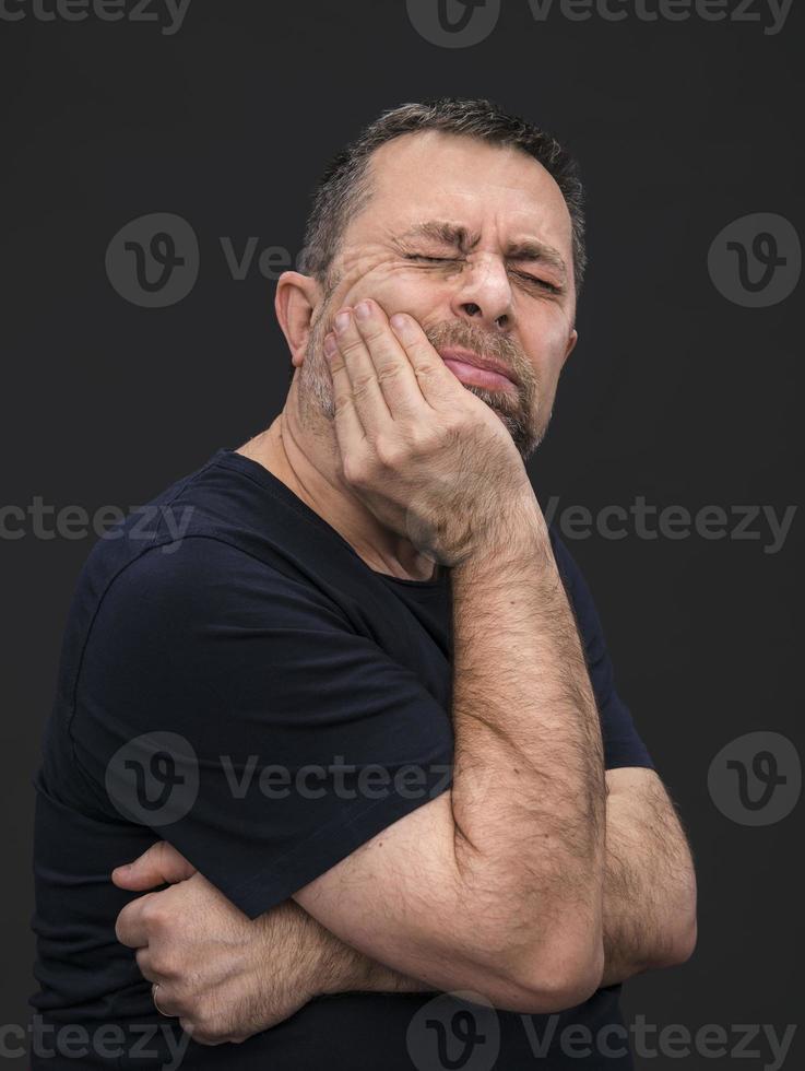 Toothache. Man with face closed by hand photo