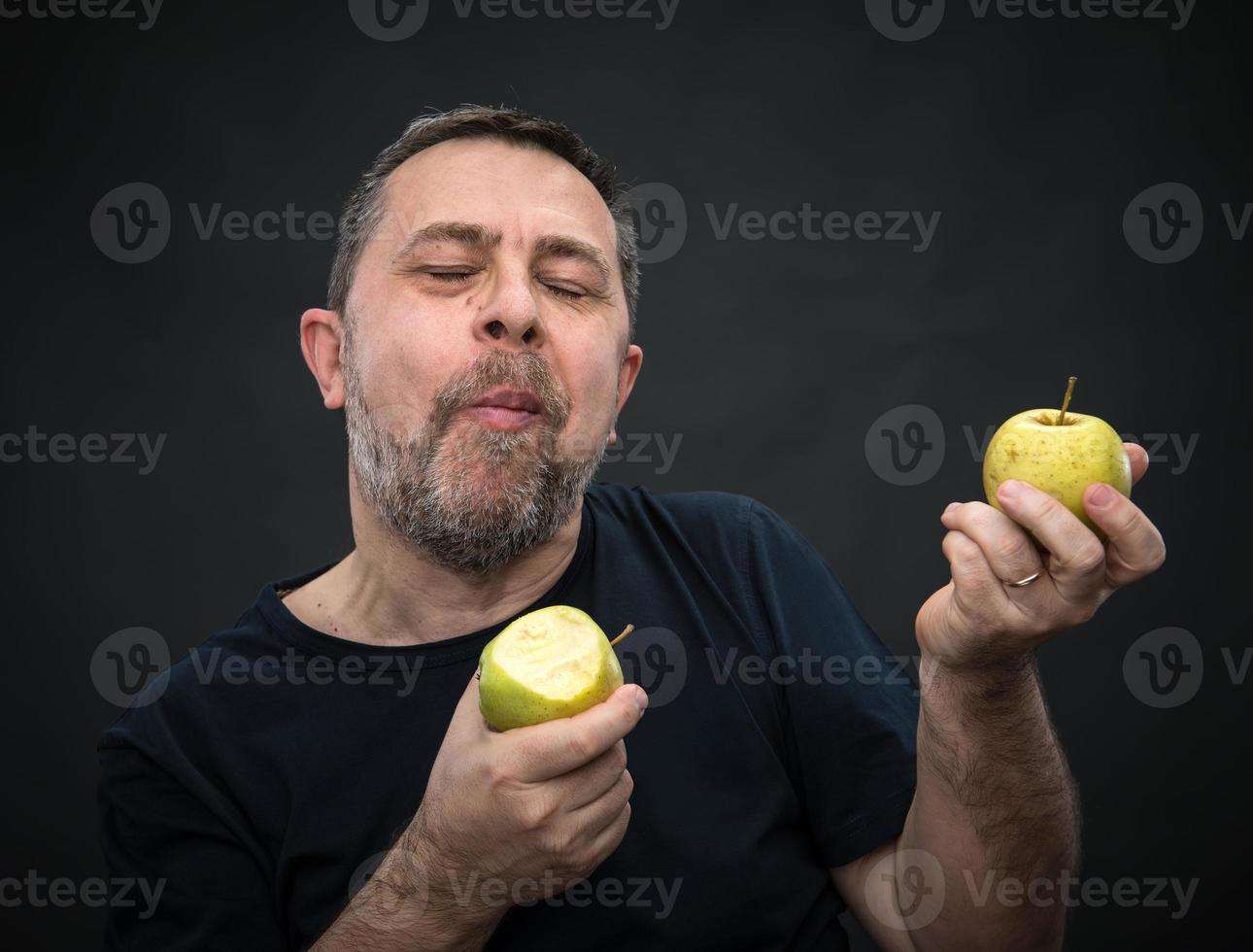 hombre de mediana edad con manzanas verdes foto