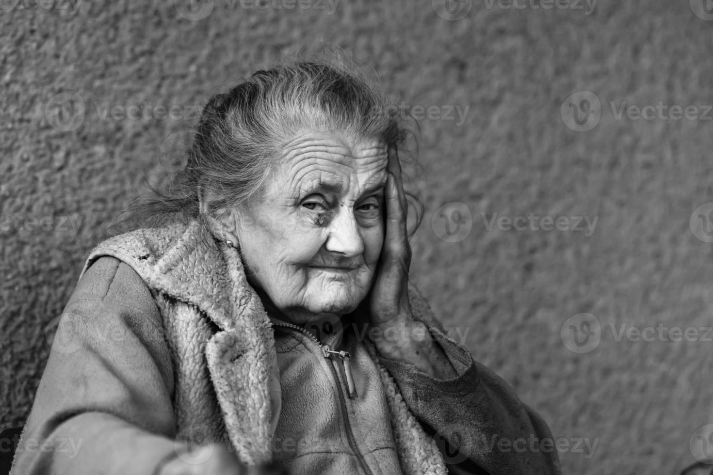 Very old and tired wrinkled woman outdoors photo