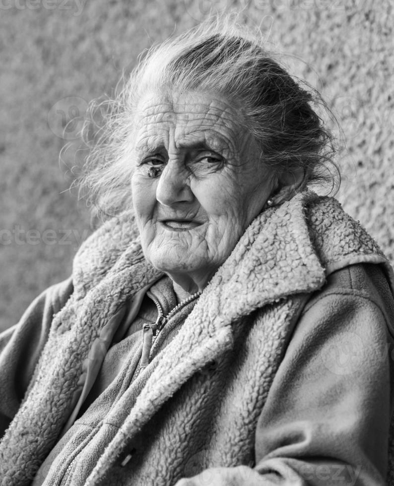 Very old and tired wrinkled woman outdoors photo