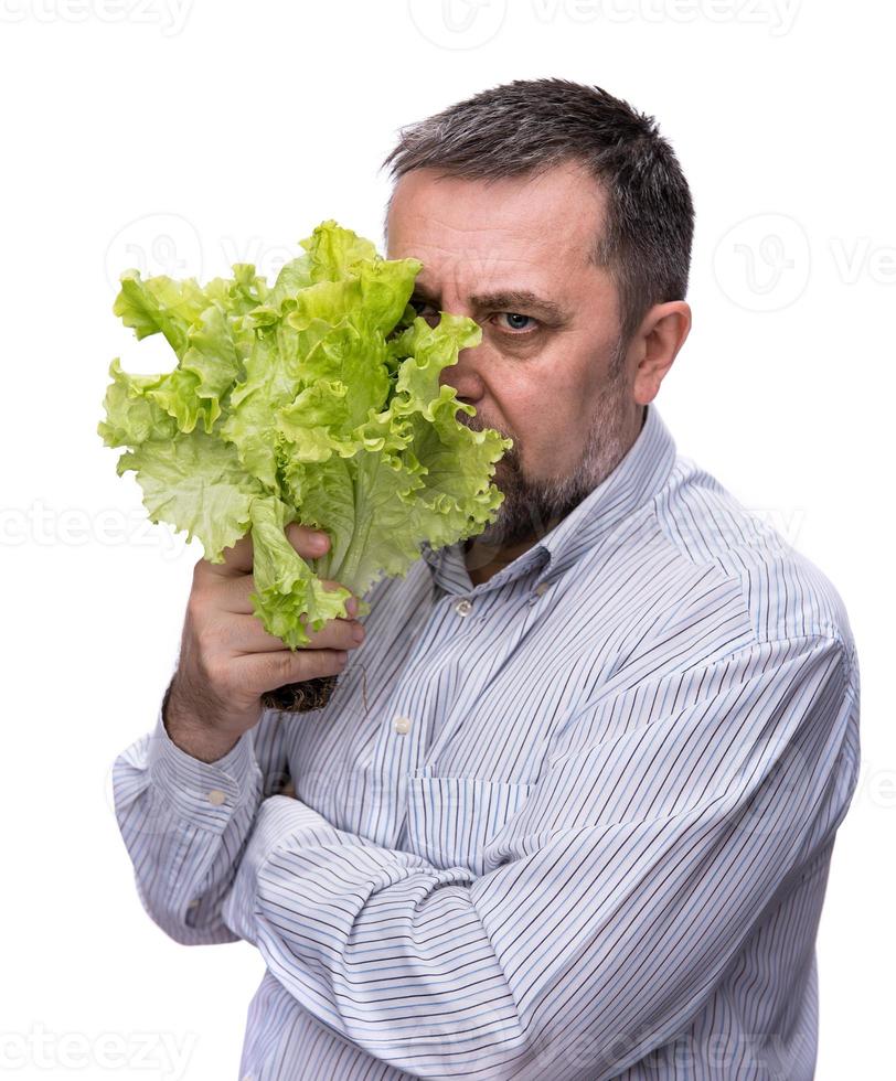 un hombre con un manojo de lechuga para una alimentación saludable foto