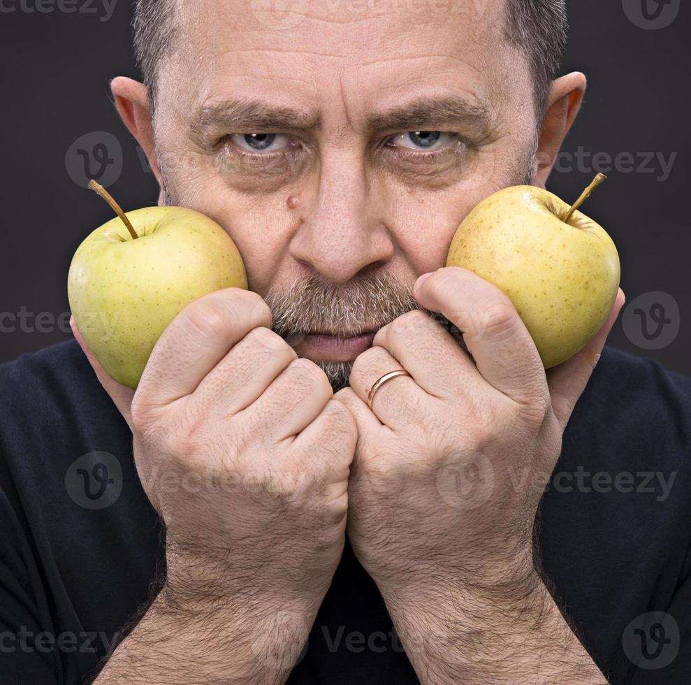 hombre de mediana edad con manzanas verdes foto