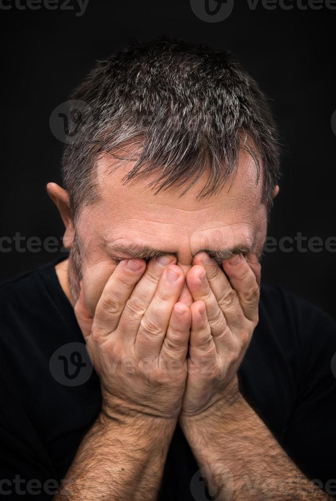 desesperación. hombre con la cara cerrada a mano foto