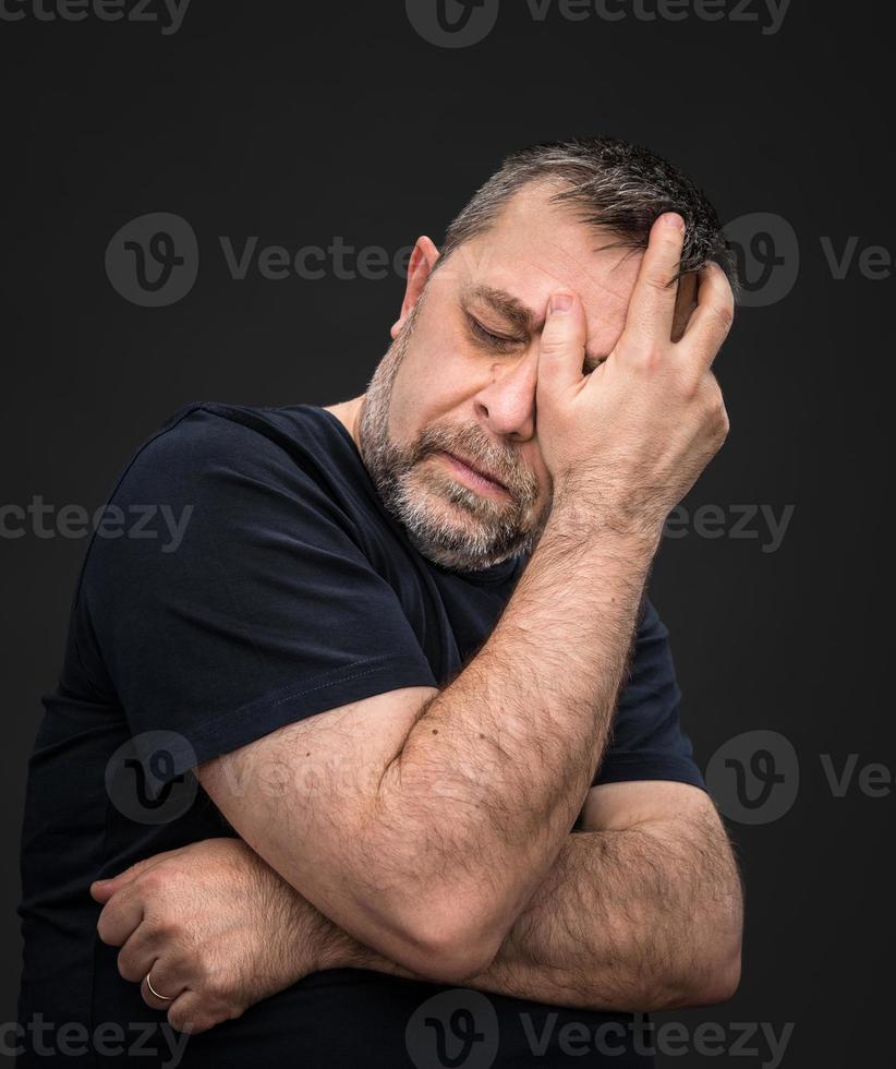 Headache. Man with face closed by hand photo