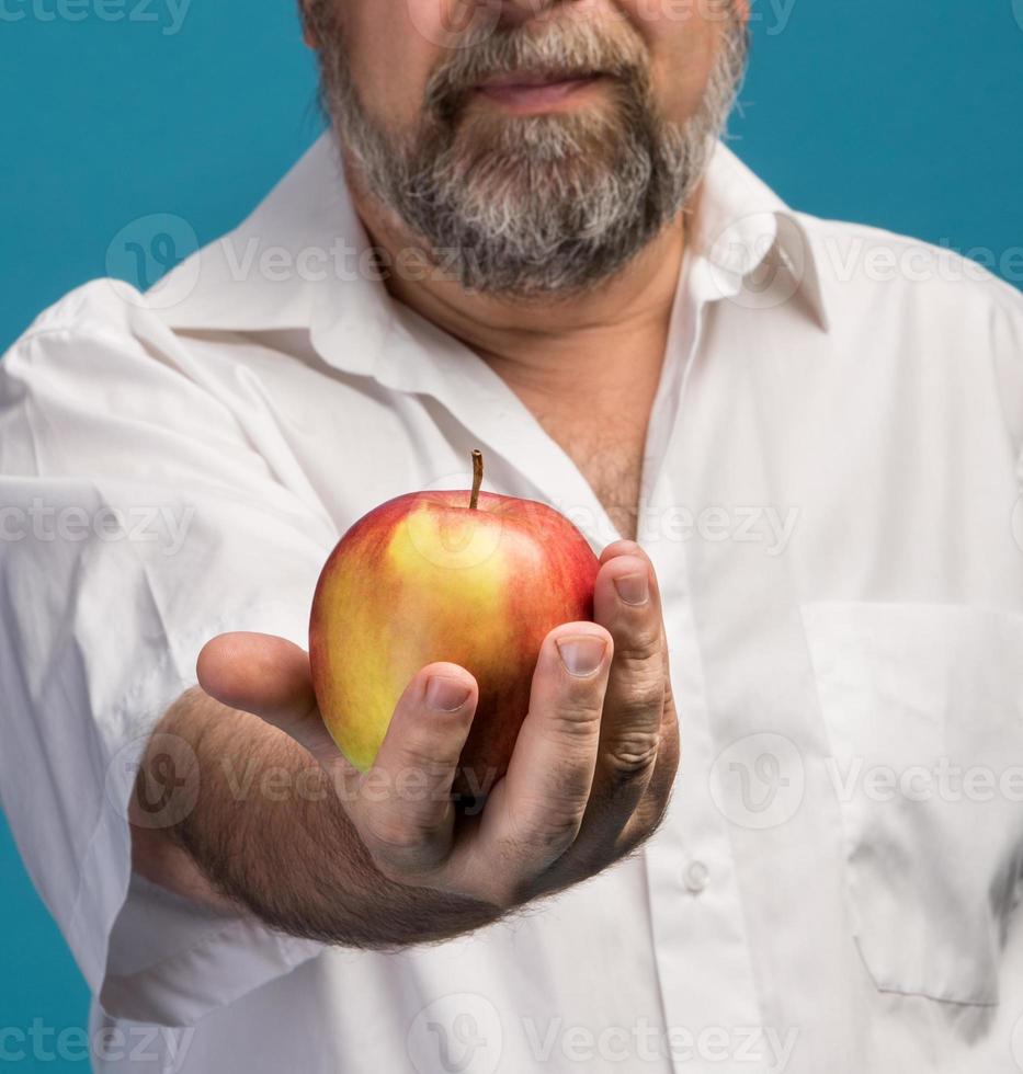 hombre con manzana roja en la mano foto