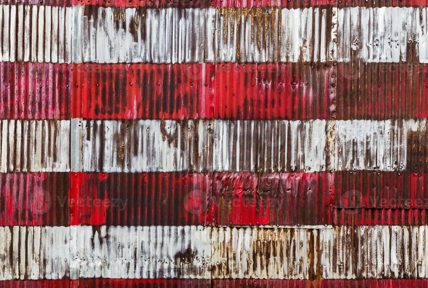 Red and white stripes hand painted on  a rusty fenc photo