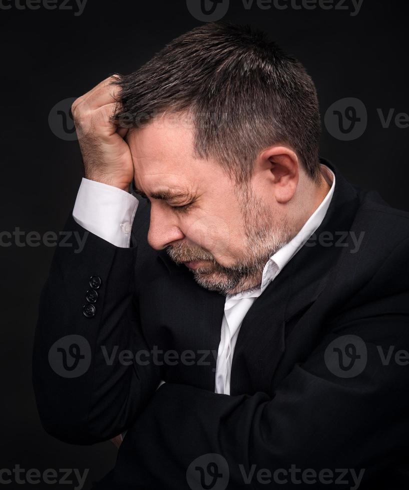 Headache. Man with face closed by hand photo