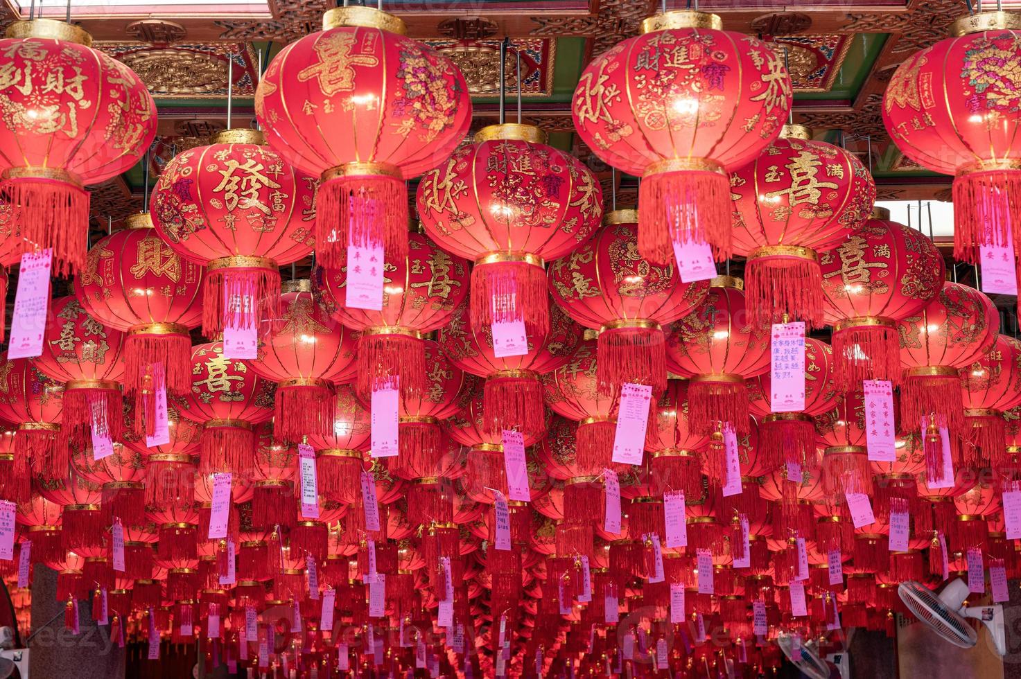 linterna china asiática con tarjeta de felicitación colgada en el templo del techo en la celebración del año nuevo foto