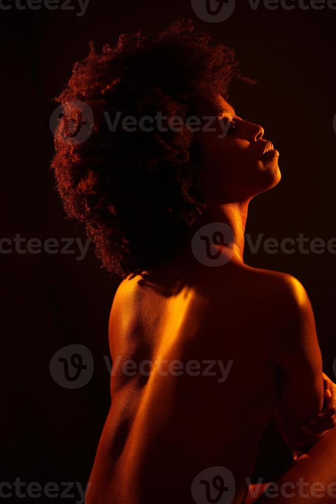 Calm black woman embracing naked torso photo