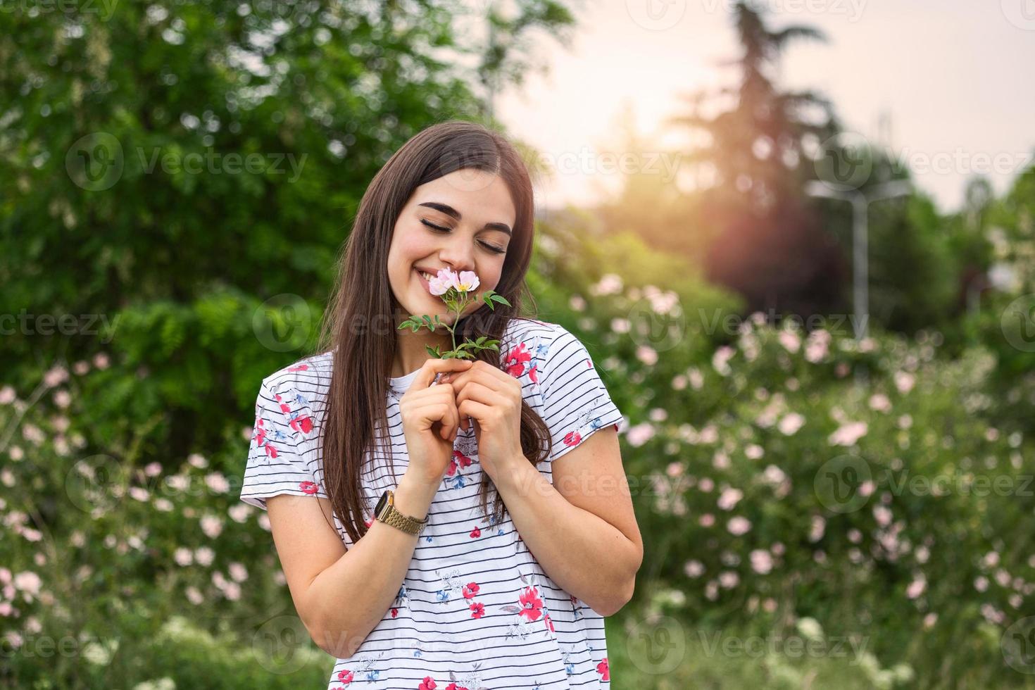 young beautiful woman smelling flowers in nature. photo