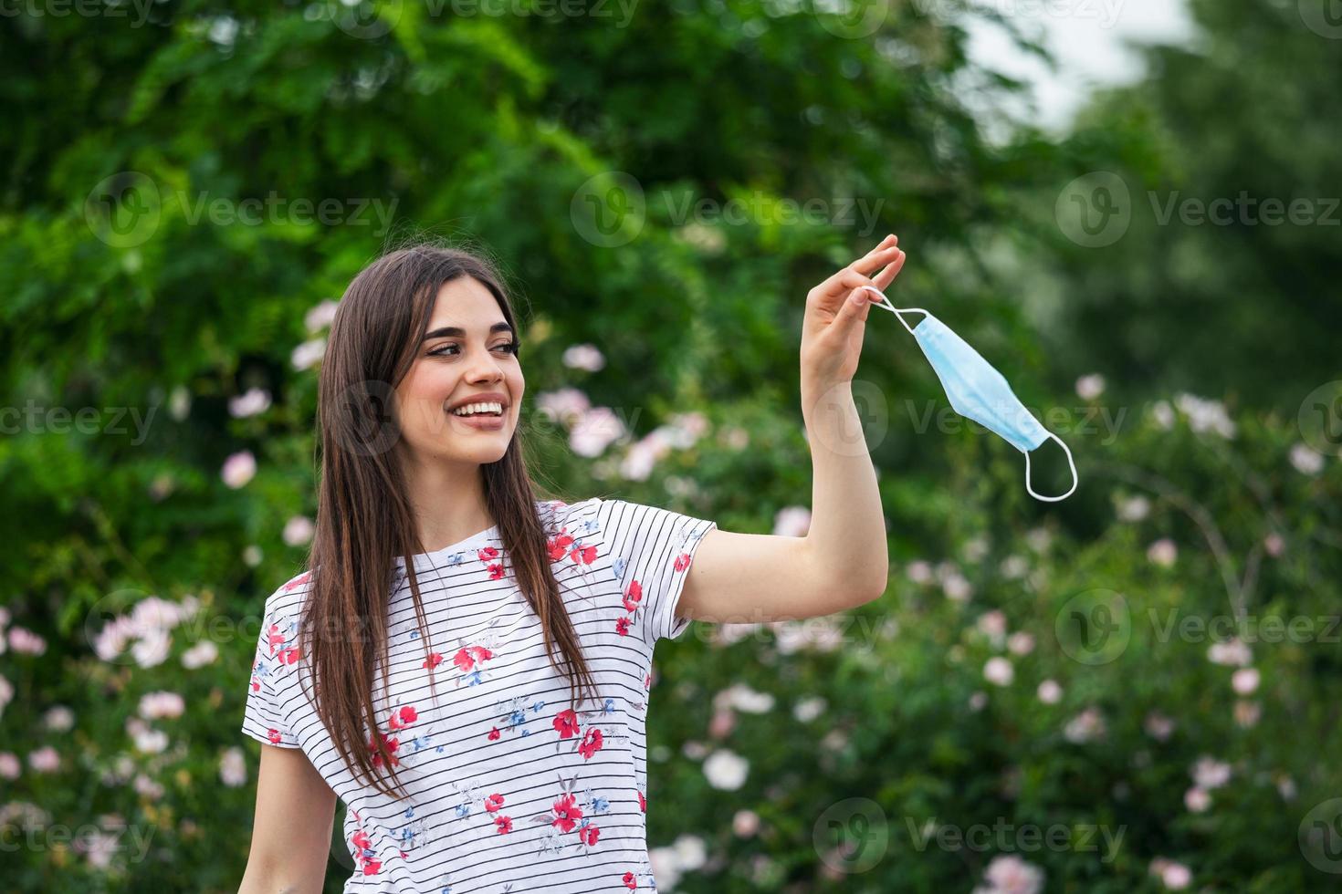 Quarantine is over concept. Woman taking off mask outdoor. We are safe. Coronavirus ended. We won. No more quarantine. Breathe deep. Take off the mask. Coronavirus is over photo
