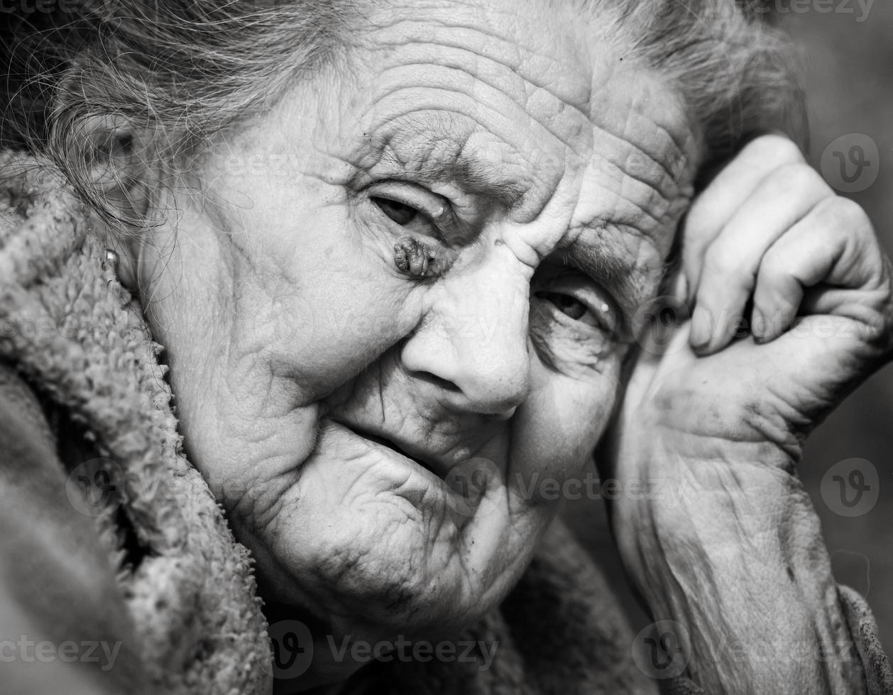 Very old and tired wrinkled woman outdoors photo