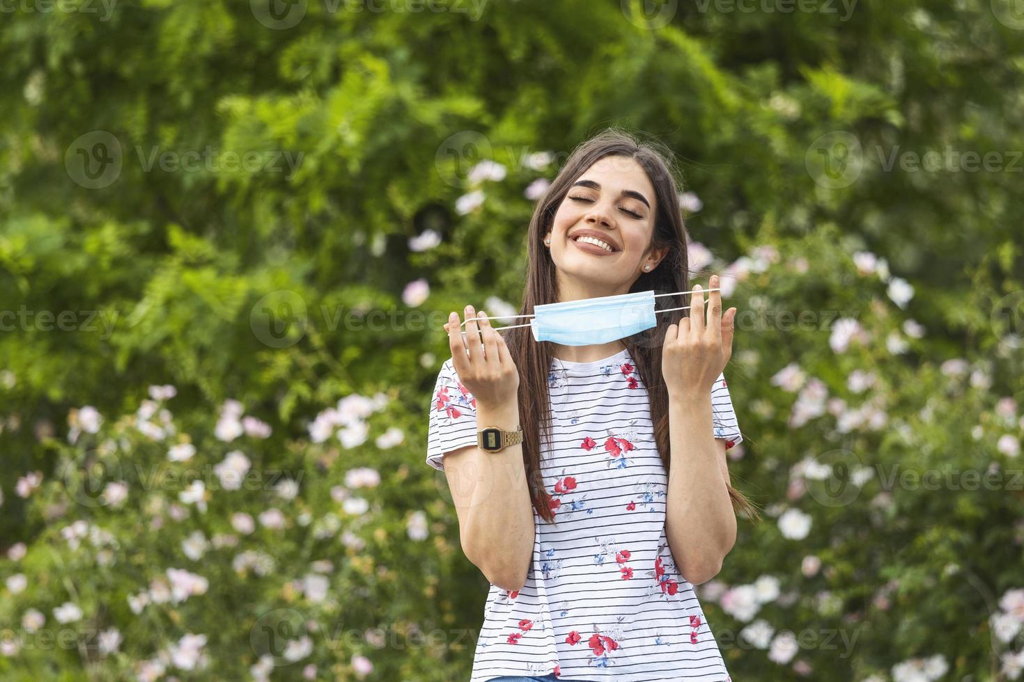 Coronavirus is over we won concept. Woman holding mask. We won sign outdoor in the sunshine freedom. We are safe. Coronavirus ended. We won. No more quarantine. Breathe deep. Take off the mask. Cure. photo