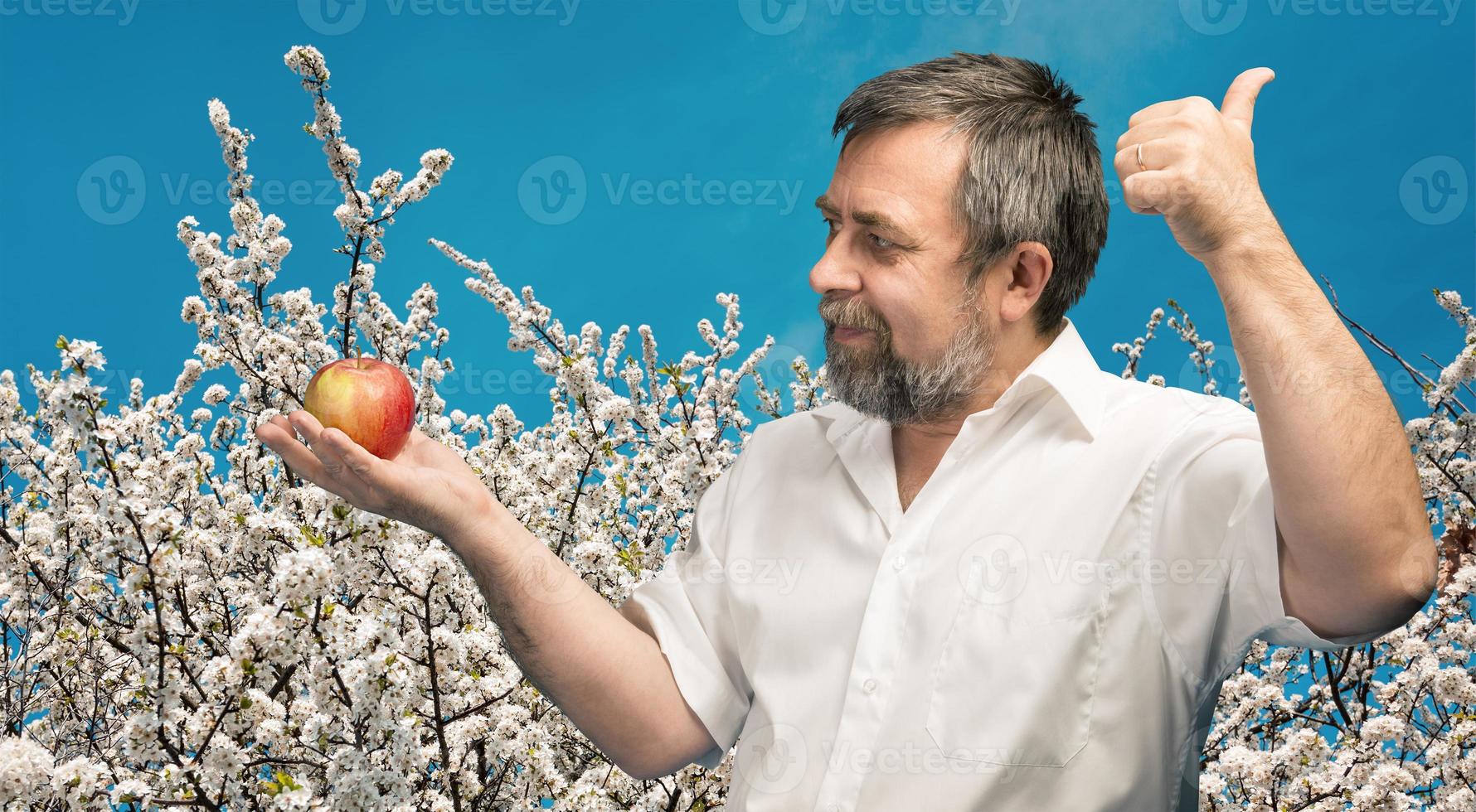 middle-aged man in white shirt with red apple photo