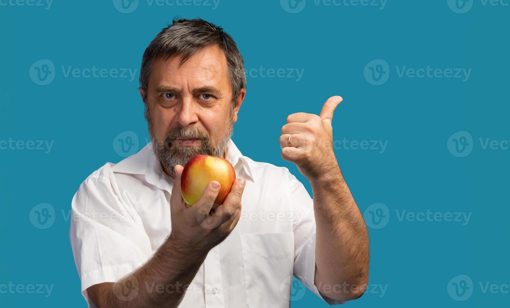 hombre de mediana edad sosteniendo una manzana roja foto