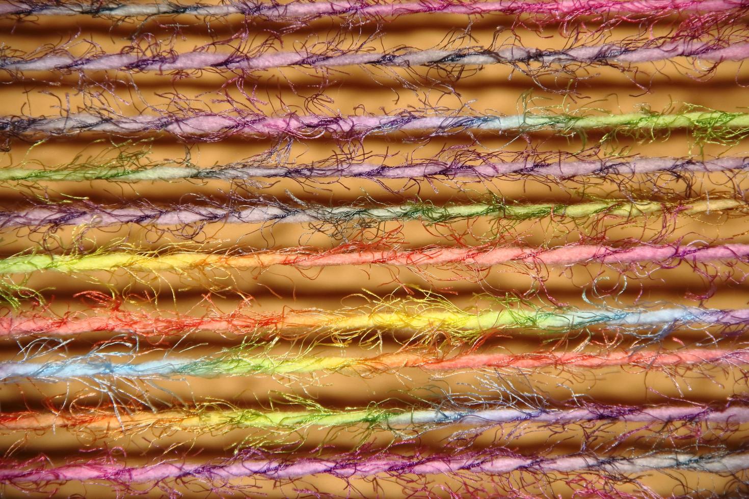 colorful yarns woven in loom frame by hand photo