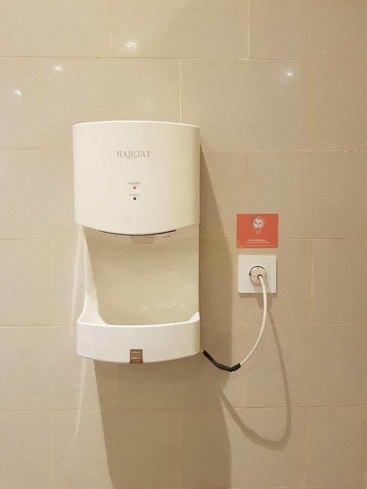 Bekasi, Indonesia in July 2019. This is the interior of a public bathroom in a hotel with shades of cream yellow and white photo