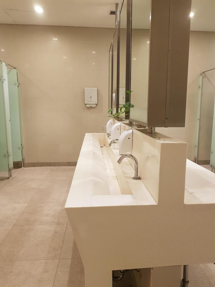 Bekasi, Indonesia in July 2019. This is the interior of a public bathroom in a hotel with shades of cream yellow and white photo