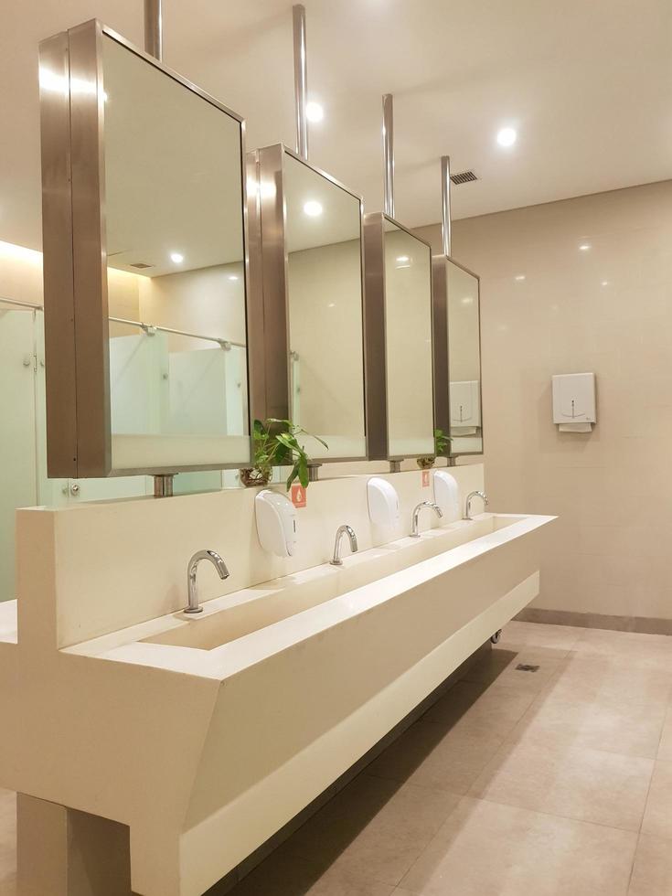 Bekasi, Indonesia in July 2019. This is the interior of a public bathroom in a hotel with shades of cream yellow and white photo