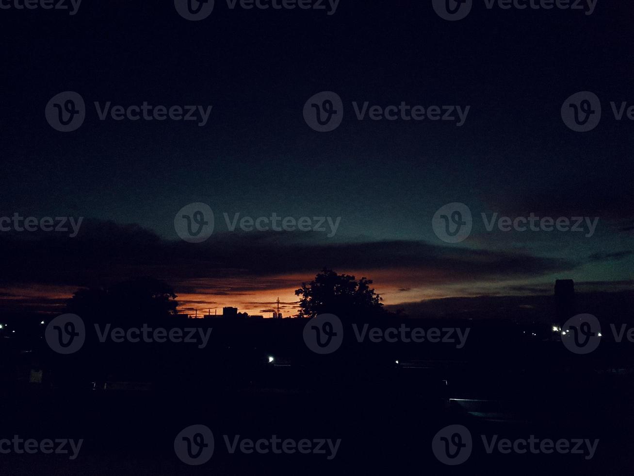 el horizonte es un hermoso cielo al atardecer con un color naranja en el cielo que se está oscureciendo foto