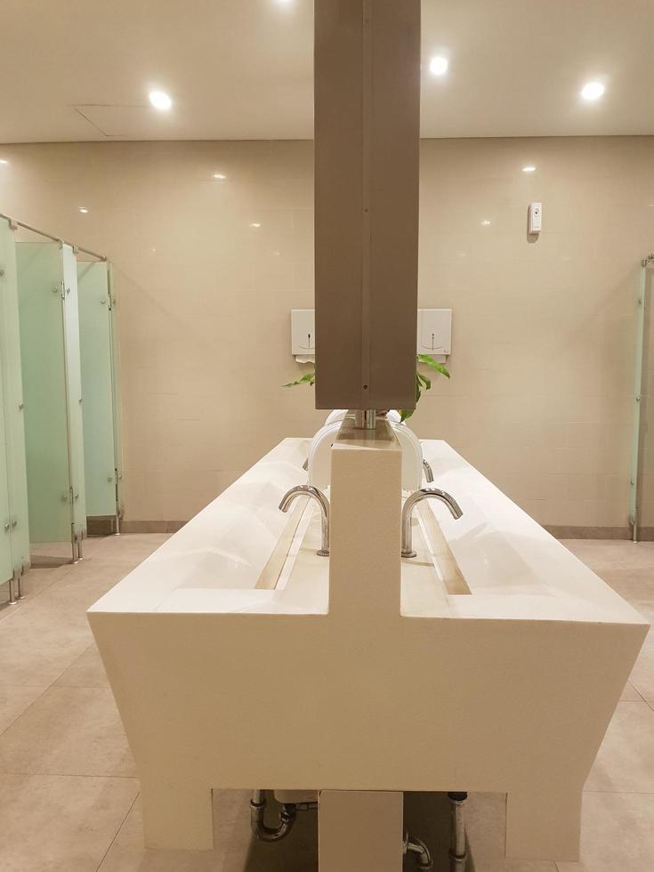 Bekasi, Indonesia in July 2019. This is the interior of a public bathroom in a hotel with shades of cream yellow and white photo