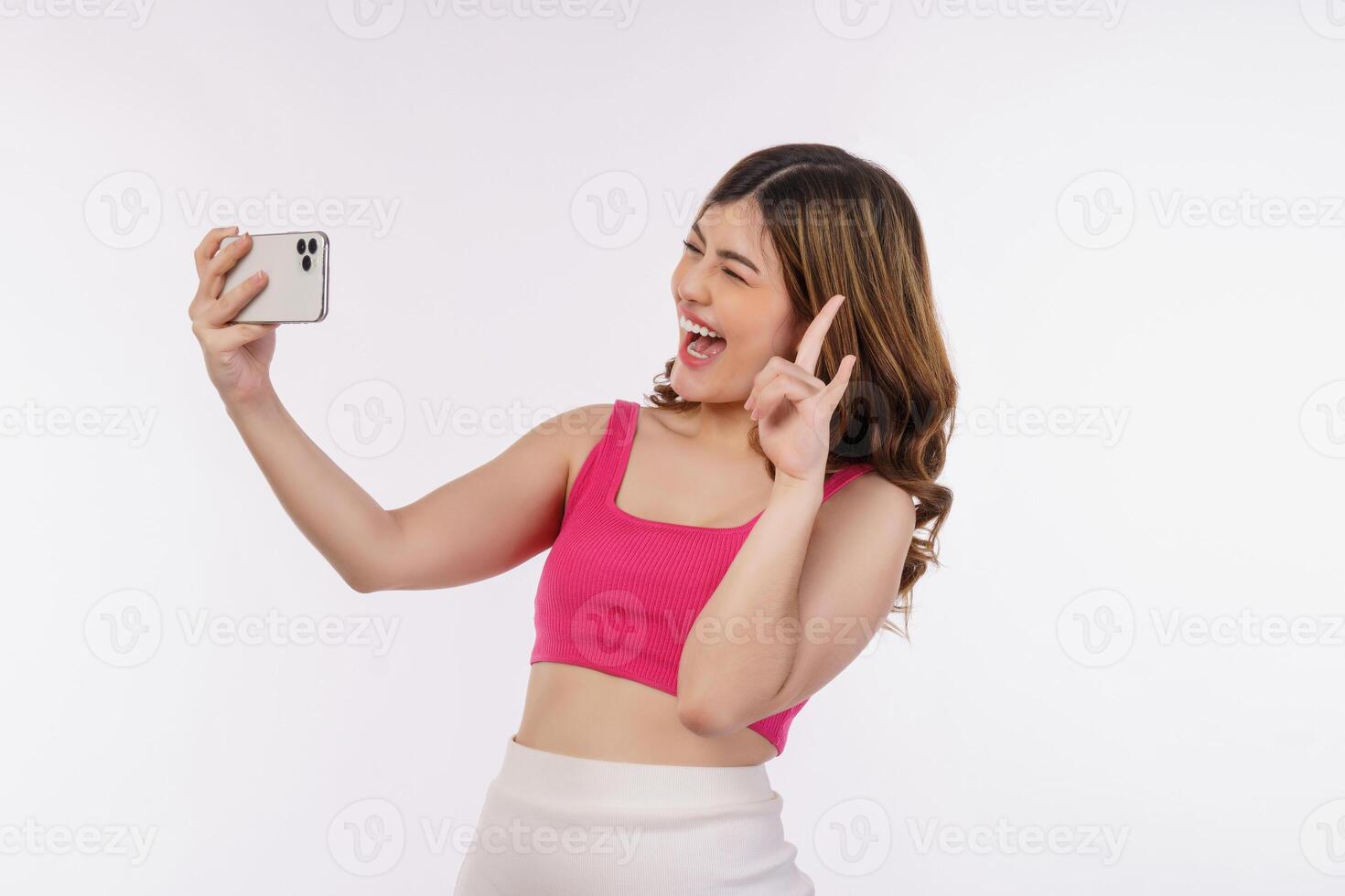 Portrait of happy smiling young woman selfie with smartphone isolated over white background photo
