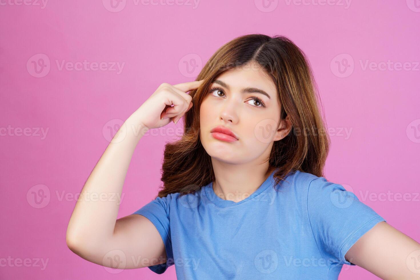 Portrait of young woman wearing casual t-shirt thinking and imagination isolated over pink background photo