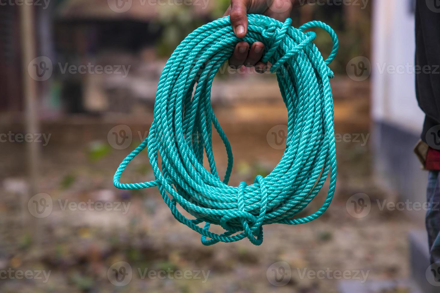 Green rope in the hand of a man on a blurred background. photo